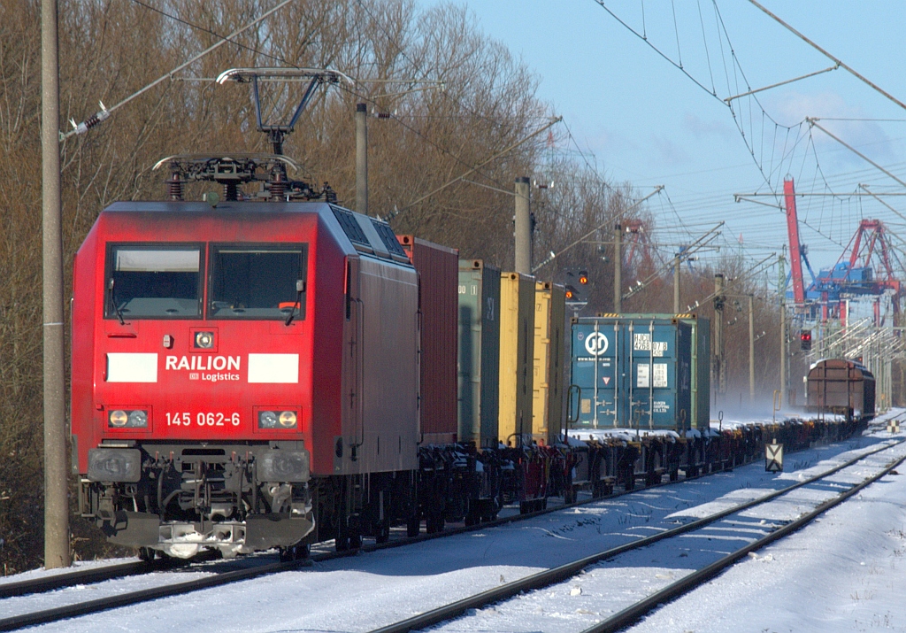 Für Freunde der Aufnahmen mit ganzen Güterzügen eignet sich HH-Moorburg besonders gut, hier konnte 145 062-6 vom Hafen kommend mit einem solchen festgehalten werden. 06.03.2010(üaV aus dem Archiv)