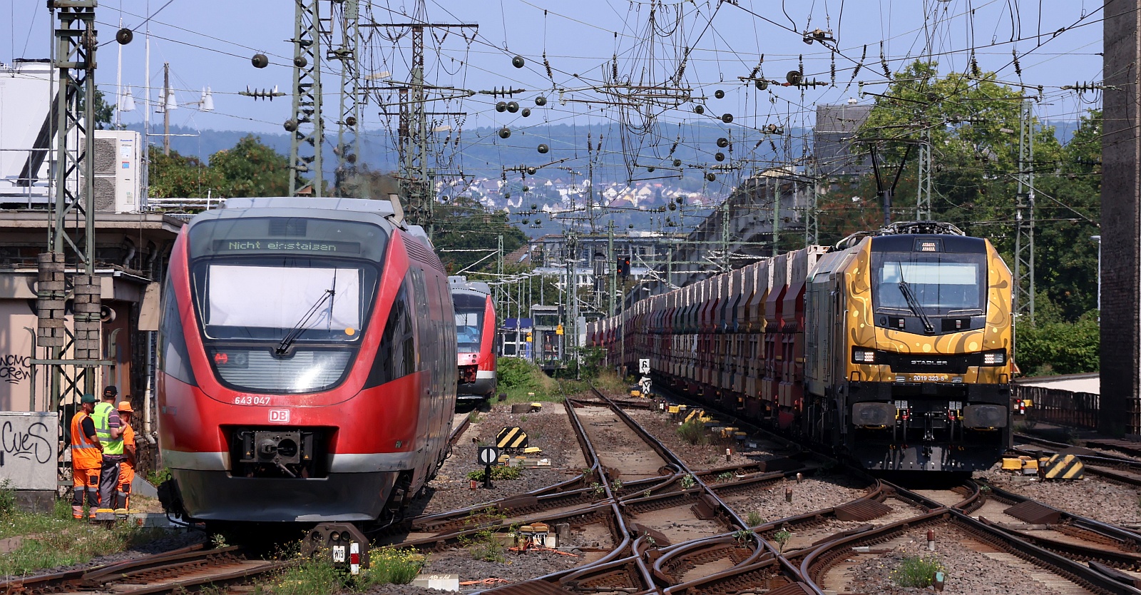 Während DB 643 043/543 in die Abstellung fuhr kam die Dispo-Tf 2019 323-5 mit langem Voestalpine/Innofreight Rocktainer ORE Ganzzug durch Koblenz gefahren. 12.08.2025 
